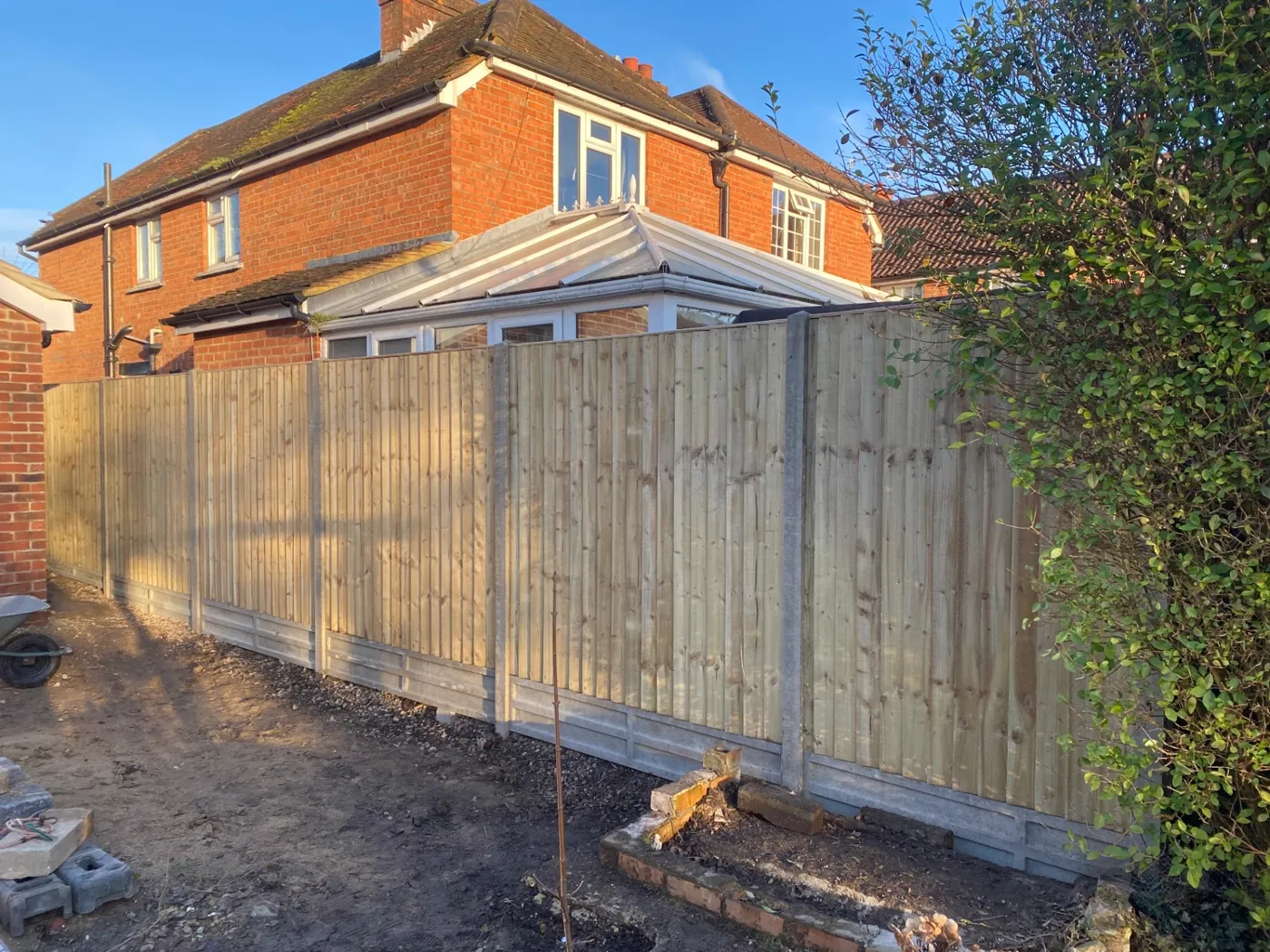 New closeboard fence installation with concrete posts and gravel boards