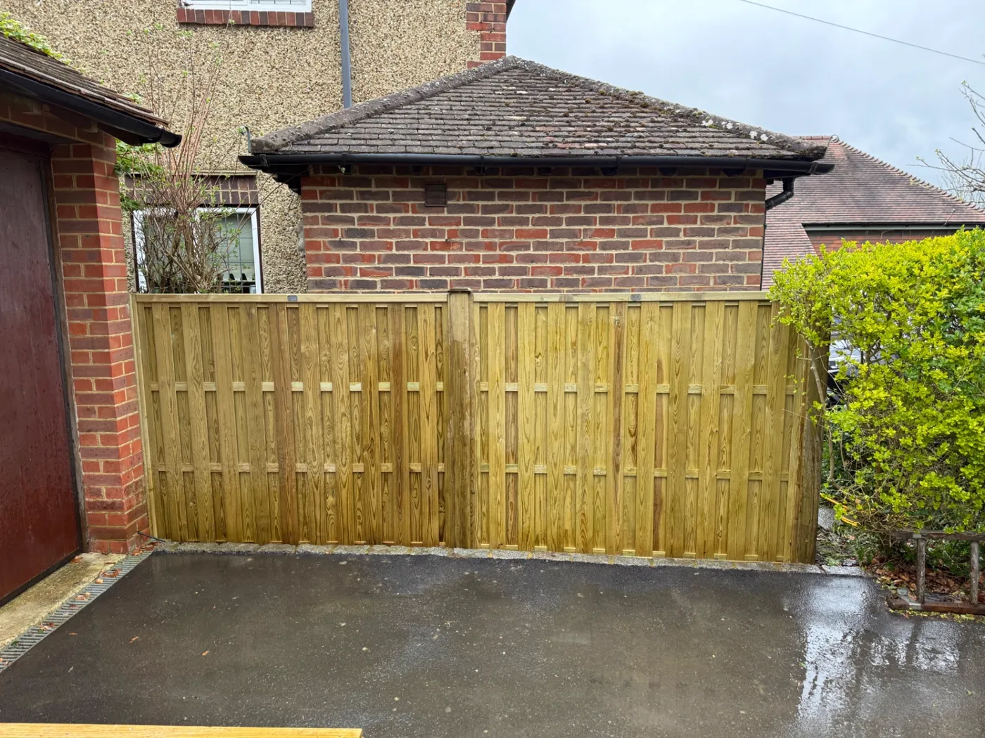Tongue and groove garden fence panels screening a driveway